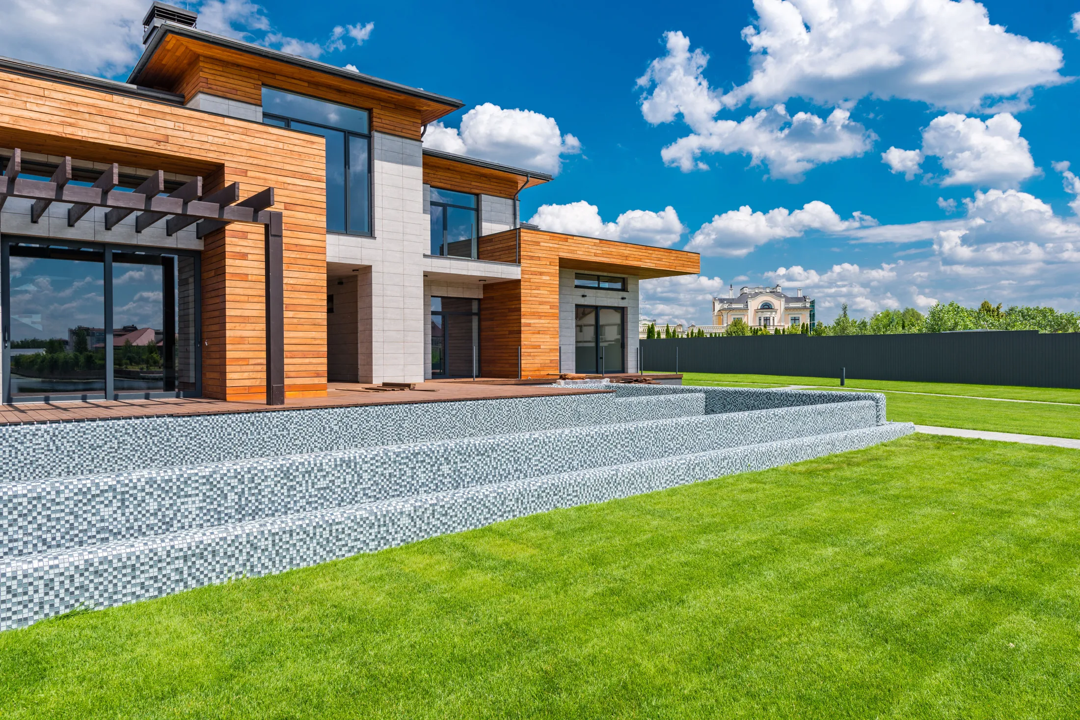 A completed Corvane Shore house with full-height glazing and a lawn