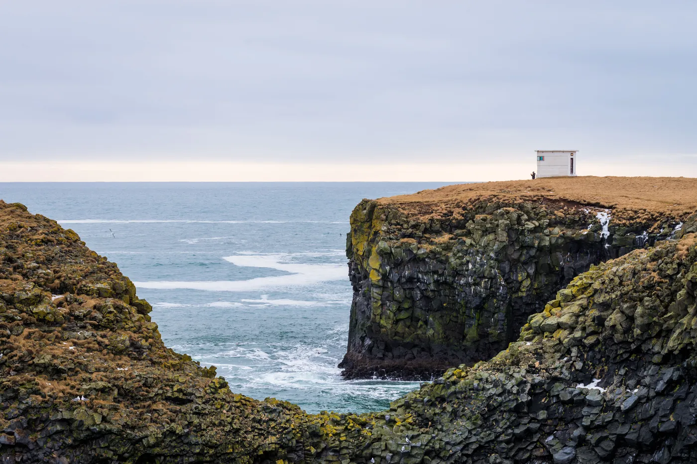 Cliffs and open ocean under a heavy sky