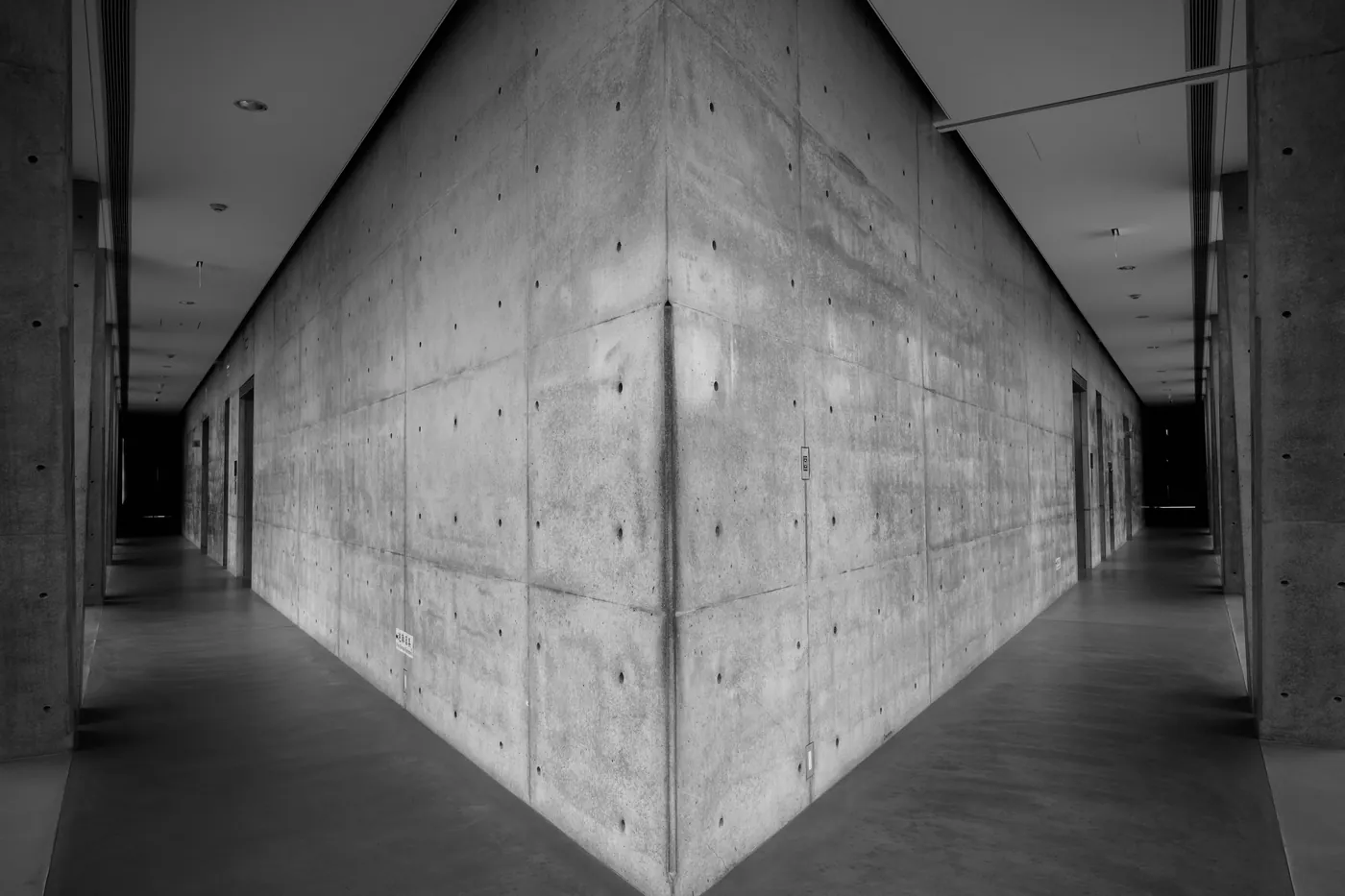 A modern concrete hallway photographed in black and white