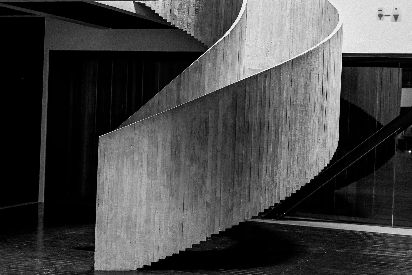 A minimalist spiral staircase photographed in black and white