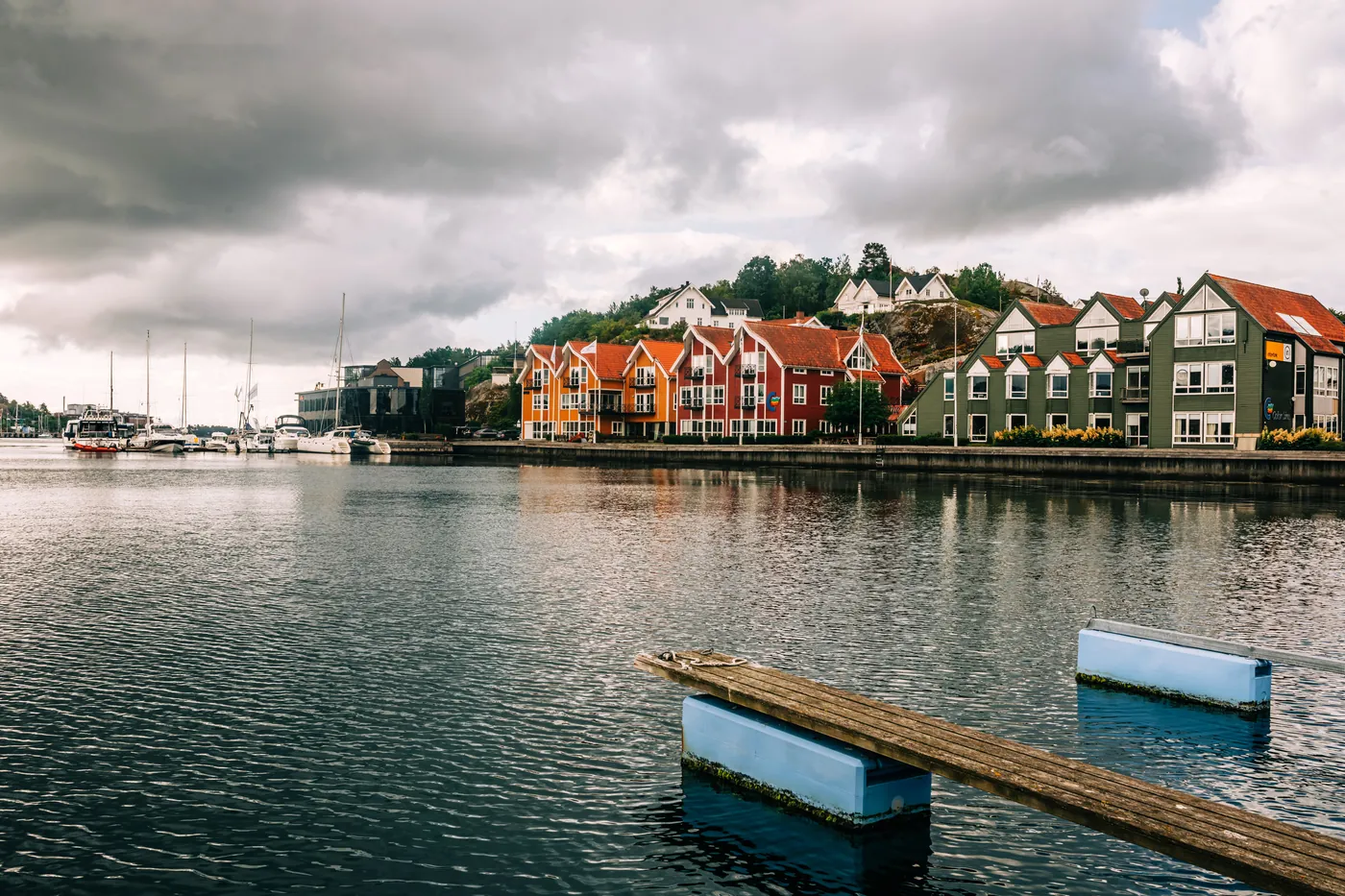 A waterfront town of timber houses under a moody sky