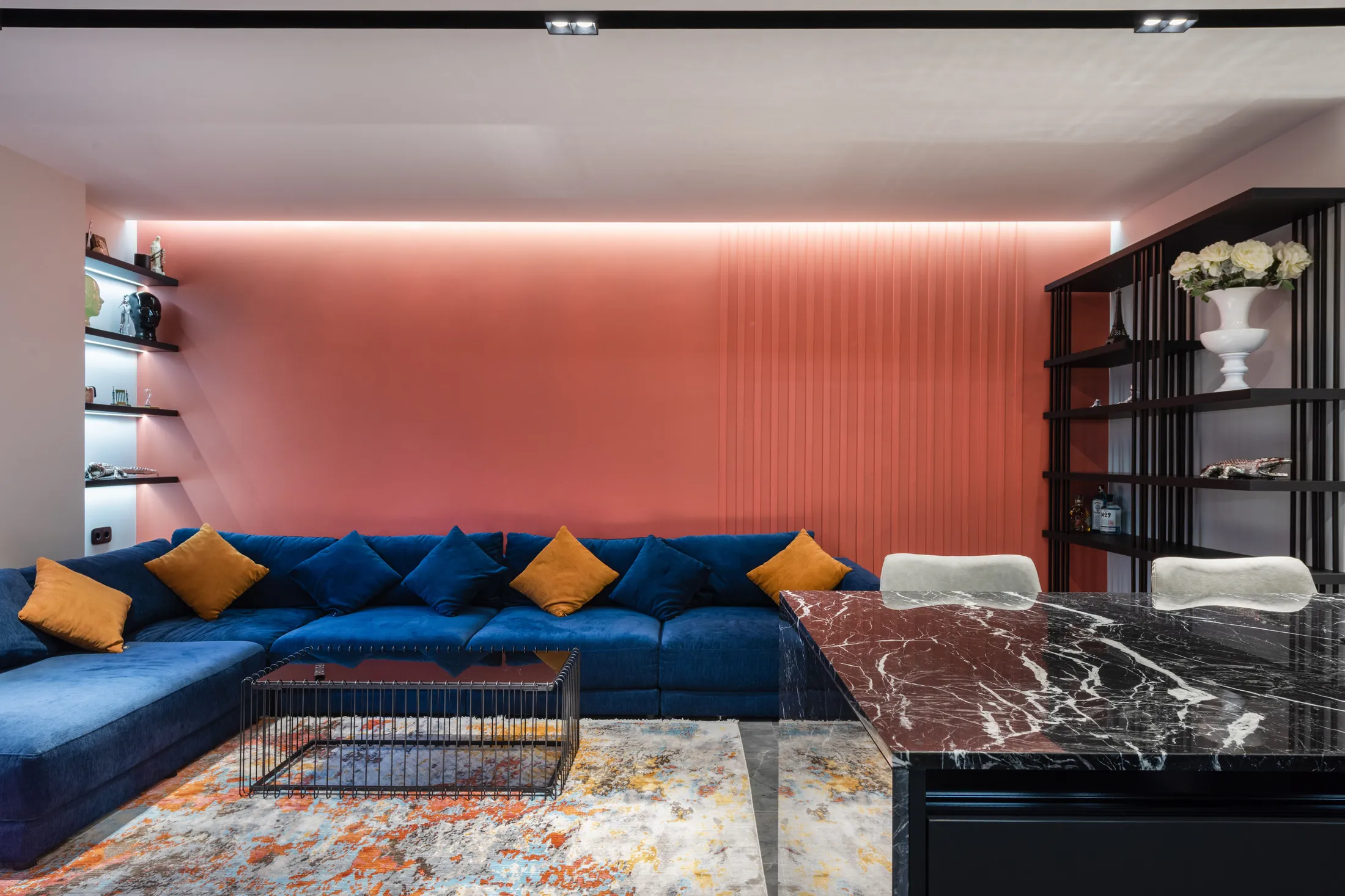 The sitting room at Quai Merisel with its coral wall and blue sofa